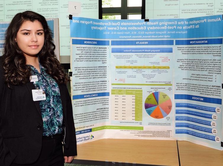 Female student stood near her research project poster